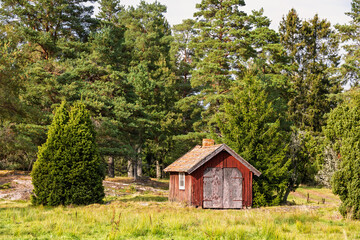 Idyllic red wooden shed by the forest edge on a meadow © Lars Johansson