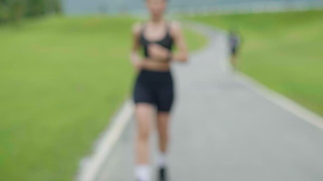 Female runner checking a smartwatch after running on a park track, representing fitness tracking, healthy lifestyle, exercise routine, wellness and longevity concept.