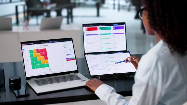 Risk Manager Analyzes Financial Data On Dual Touchscreen Laptop