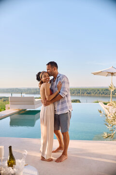 Affectionate man kissing his wife enjoying in romantic summer holiday.