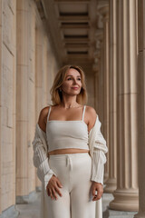 Fototapeta premium Woman White Outfit Columns Building Fashion