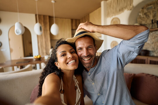 Happy couple having fun while taking selfie and looking at camera.