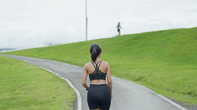 Woman running along a scenic outdoor path with mountain views, representing fitness, healthy lifestyle, endurance, wellness and longevity concept.