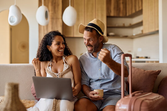 Happy couple celebrating after booking their summer vacation online.