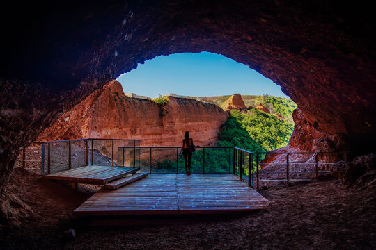 silhouette of hiker standing on observation deck inside cave looking at ancient roman gold mine landscape at las medulas in spain
