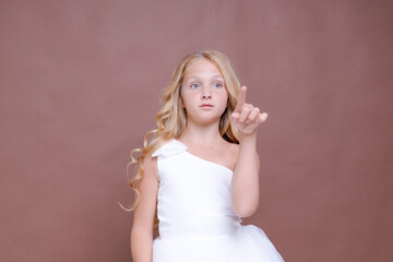Fototapeta premium Caucasian Blonde Young Girl in White Tulle Gown Smiling on Brown Studio Backdrop Front View