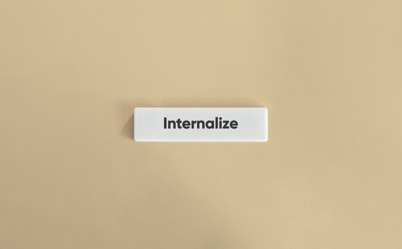Internalize word on white block on beige background