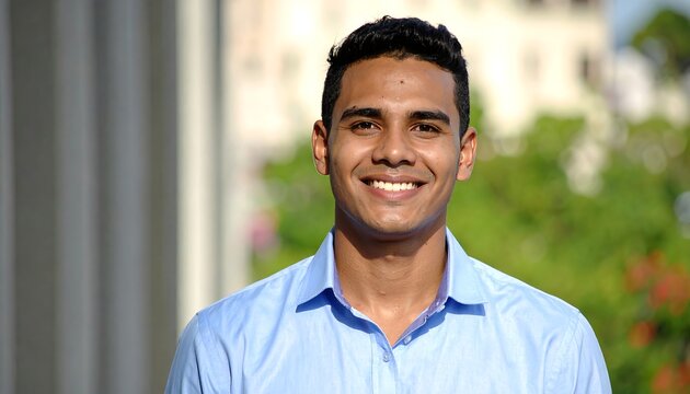 Smiling Young Man Standing Outdoors in Sunlit Garden Setting