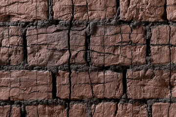 Fototapeta premium Weathered dark red brick wall background with deep cracks