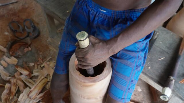 Craftsman Carving Cylindrical Wooden Object by Hand