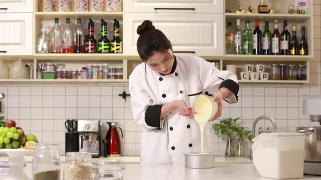 Master pastry chef baker pouring dough or cake batter into metal ring molds for baking preparation a cake or bread, ideal for cooking food blogs, confectionery, culinary in modern kitchen
