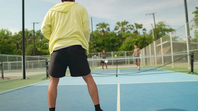 Active male and female pickleball players practice together on an outdoor court, improving agility, teamwork, fitness, coordination, and healthy lifestyles while enjoying friendly matches, recreation,