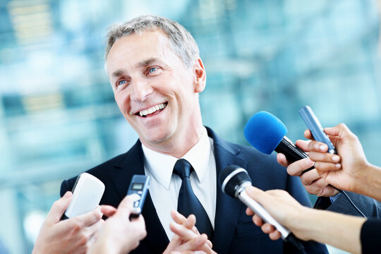 Interview, senator and smile with man and microphone for journalist, political campaign and reporter. News broadcast, press conference and government ambassador with people for speaker and election