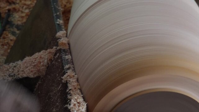 Woodworker Shaping Cylindrical Wood on Lathe