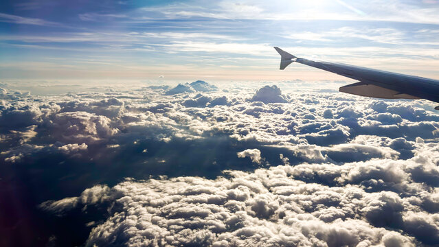 panoramic view shows an aerial view above a thick layer of fluffy white clouds, with sunlight filtering through the atmosphere