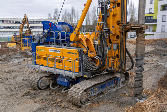Metz, France - February 20th 2020 : View on a yellow and white drilling rig Bauer BG 36 for special foundations on a construction site before the construction of a residential building.