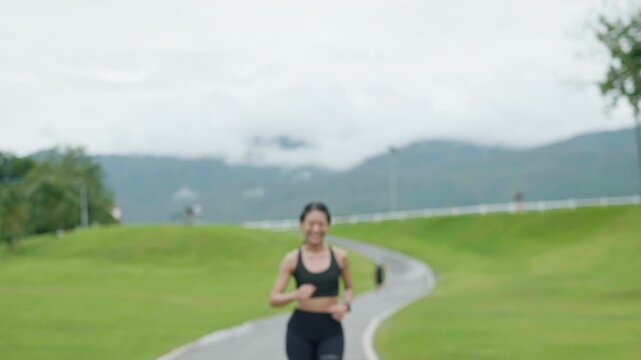 Female runner celebrating after reaching the finish line on a scenic outdoor path, representing fitness achievement, healthy lifestyle, motivation and longevity.