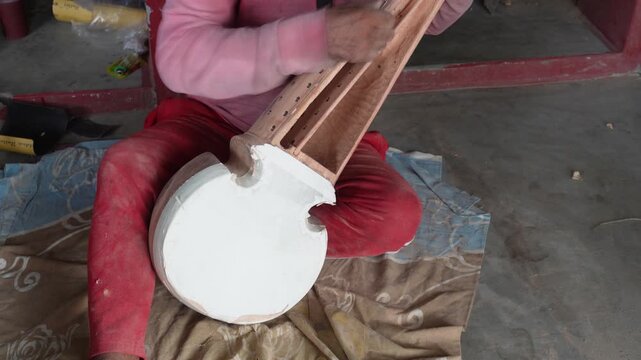 Craftsman Working on Traditional Wooden String Instrument