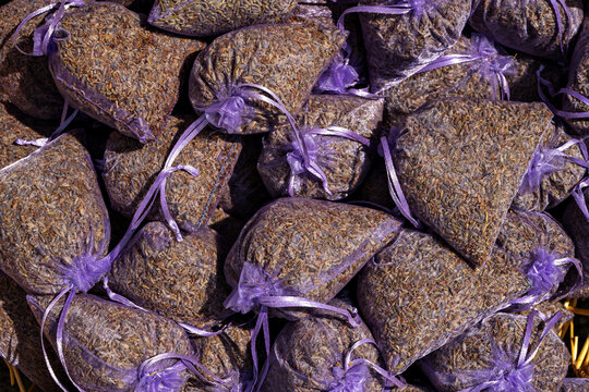 Bags of dried lavender displayed on a market table during daytime