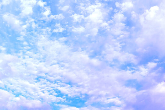 Motion in blue sky.Pink tints on a white clouds. Atmospheric mood