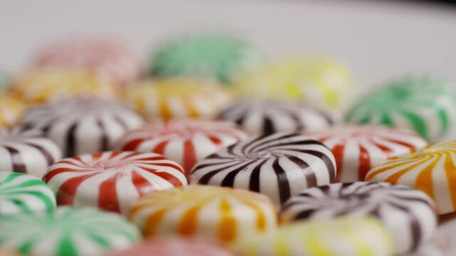 Close up top down view of colorful swirl hard candies resting on a clean white surface