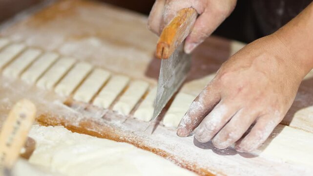 Close Up of Baker Cutting Dough with Bench Scraper in Bangkok