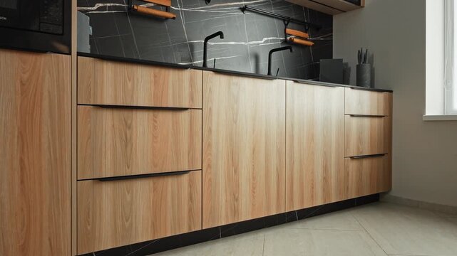 Chic Light Wood Cabinets Featuring Integrated Appliances And Sophisticated Marble Backsplash