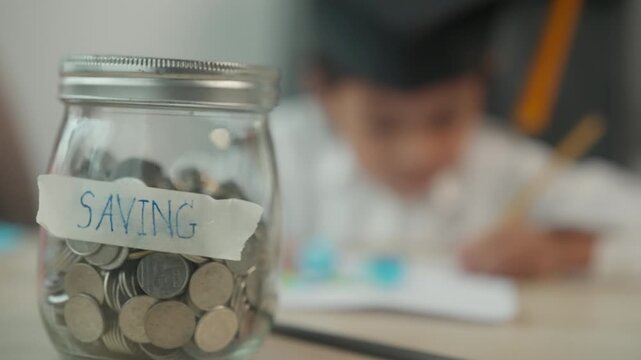 Child Saving Money in Coin Jar While Drawing at Home for Financial Education