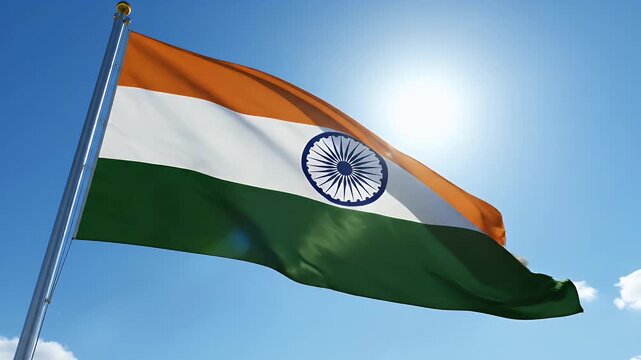 Vibrant Indian Flag Waving in Bright Sunlight - A vibrant Indian flag, featuring saffron, white, and green bands with the Ashoka Chakra, flutters dynamically against a clear blue sky.
