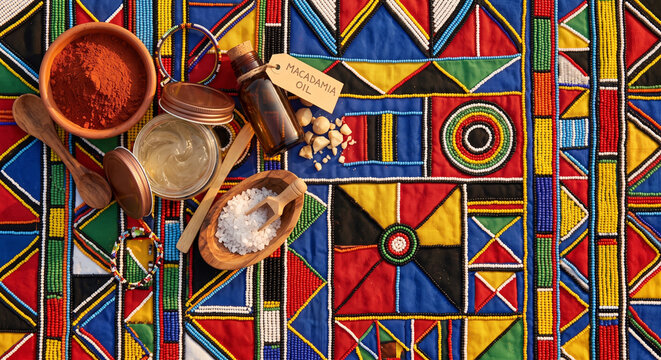 Overhead photo of South African rooibos and marula beauty items on grass mat