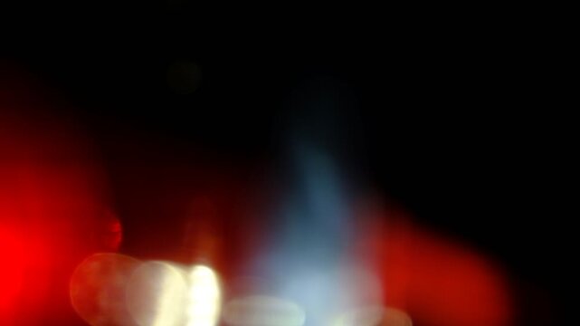 Lens flare anamorphic glow drifting horizontally with dual-tone red and blue highlights for cinematic transition overlay on black background