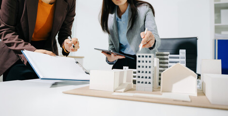 Fototapeta na wymiar Real estate broker agent presenting and consult to customer to decision making sign insurance form agreement, home model, concerning mortgage loan offer in office