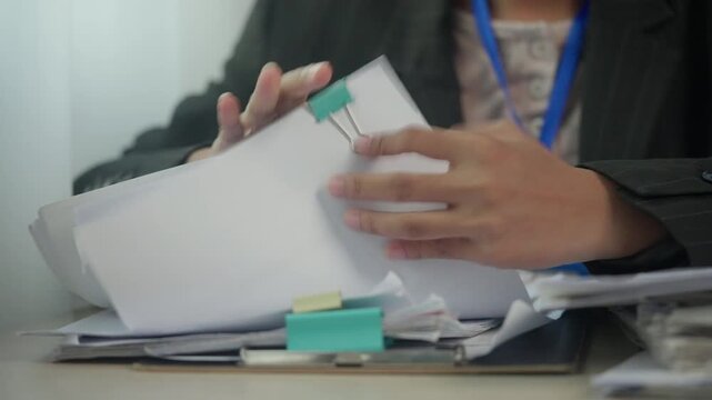 Administrative Staff Organizing Business Paperwork and File Tabs for Office Efficiency