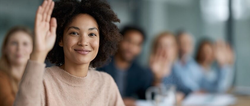Diverse group in classroom with one person raising hand to speak