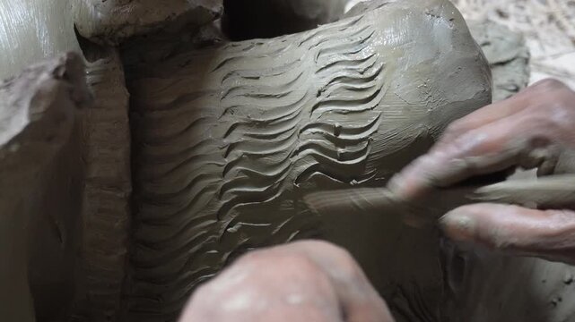 Hands Sculpting Clay with Wavy Textured Patterns