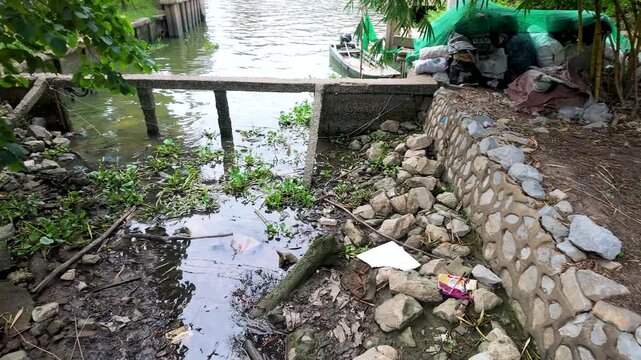 Plastic Garbage and Waste Accumulation on Muddy Riverbank in Thailand
