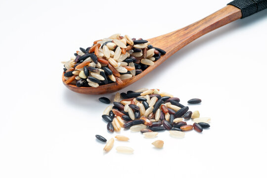 Seven different organic rice grains in a wooden spoon on white backgroiund, Healthy food concept