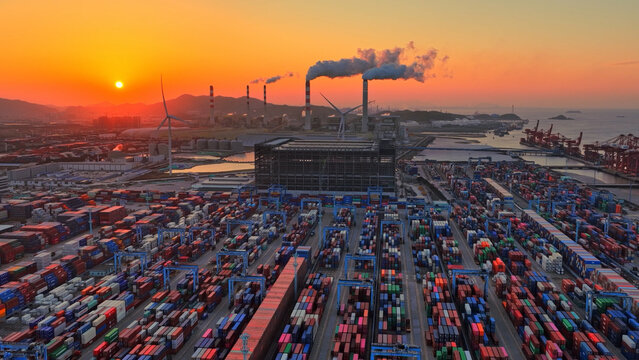 Industrial port area large shipping cargo containers sunset. Fossil fuel power plant air smoke stacks, wind turbine. Global logistics trade industry terminal. Windmill energy factory. Smoking chimneys