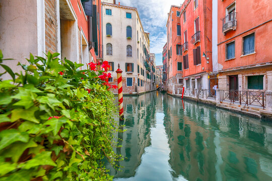 Amazing  cityscape of Venice with narrow canals, boats and gondolas and bridges with traditional buildings.