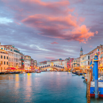 Gorgeous sunset and evening cityscape of Venice with famous Canal Grande and Rialto Bridge.