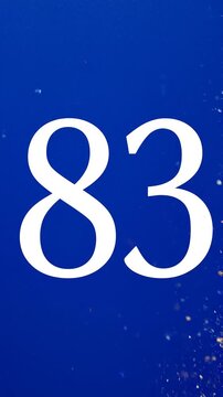 Gold Glitter Blow‑Away Reveal of Number 83 on Solid Background