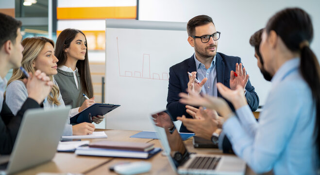 Manager explains a business chart to colleagues during a planning meeting, showing strategy, data analysis, teamwork and corporate communication.