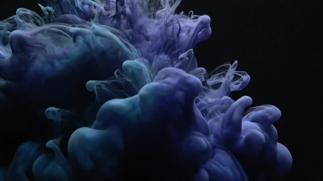 Blue and purple ink swirling slowly in water on black background