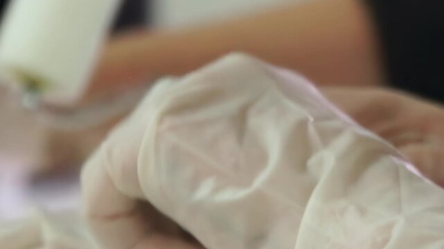 Focused hands clad in gloves expertly create a stunning piece of art. The close-up reveals intricate movements, showcasing the artist's skill and dedication to their craft.