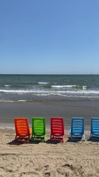 serie di sedie in plastica colorata in riva al mare