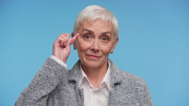 Senior Woman Making Crazy Gesture Near Temple