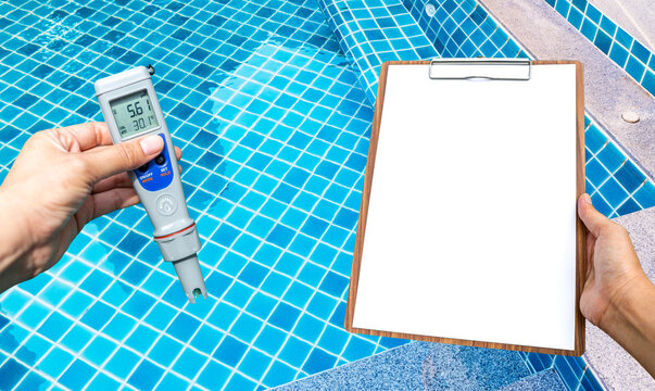 Swimming pool water testing test kit with blank report paper on wooden clipboard over clear pool water background, quality water tester technology