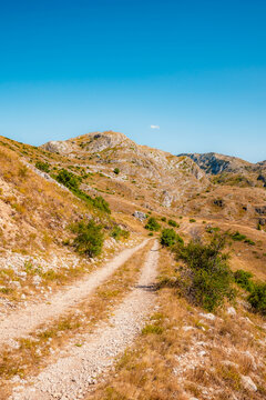 Grand panoramic view from Prutas peak at sunset, overlooking the dramatic limestone ridges and deep valleys of Durmitor National Park, Montenegro.