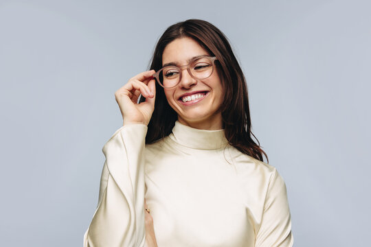Woman adjusting glasses in studio