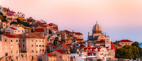 evening at Banj beach with a view of the historic Sibenik city center and fortress under a colorful sunset sky, Croatia. © Zedspider